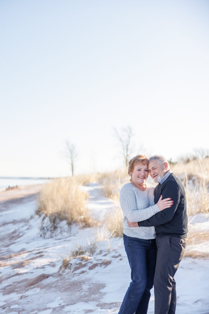 Jane and Bruce embracing joyfully in a snowy Duluth landscape, celebrating their winter photography session by Superior Sunset Studio.