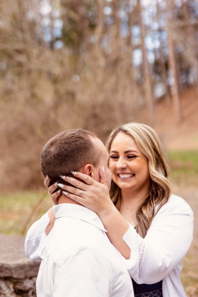 Bianca and Nick sharing an intimate moment during their engagement session in Hayward, WI, with joyful expressions and a natural outdoor backdrop.