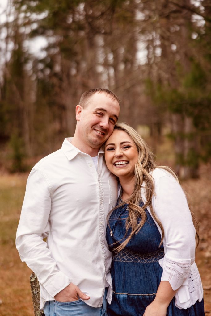 Bianca and Nick smiling together in a natural setting during their engagement session in Hayward, WI, showcasing love and joy.