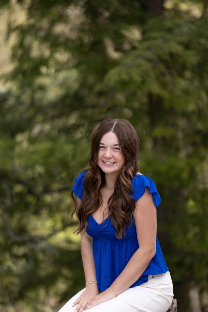 Julia's senior portrait in Hayward, WI, showcasing a bright blue top and natural smile.