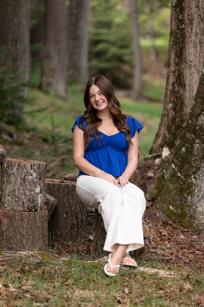 Julia's senior portrait session in Hayward, WI, showcasing a smiling senior girl seated on a