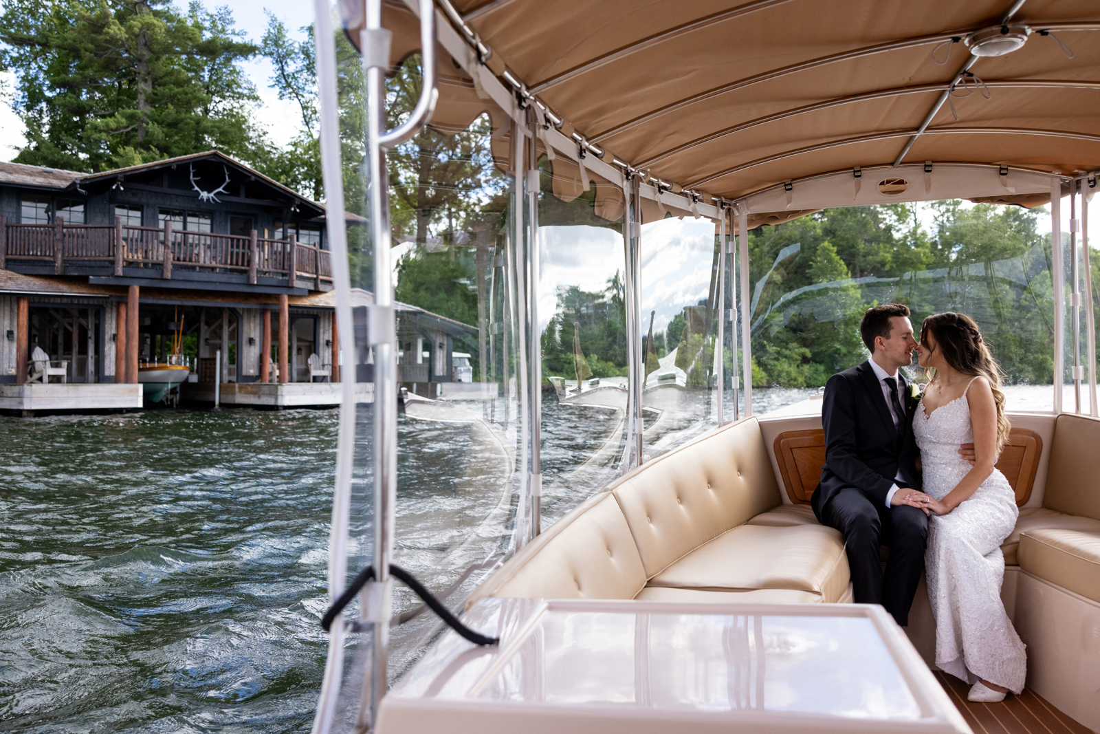 Bride and groom embracing on boat transfer to Stout’s Island wedding resort.