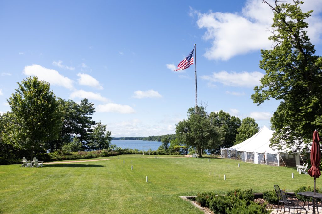 American flag waving at Stout’s Island wedding venue and reception tent on Red Cedar Lake