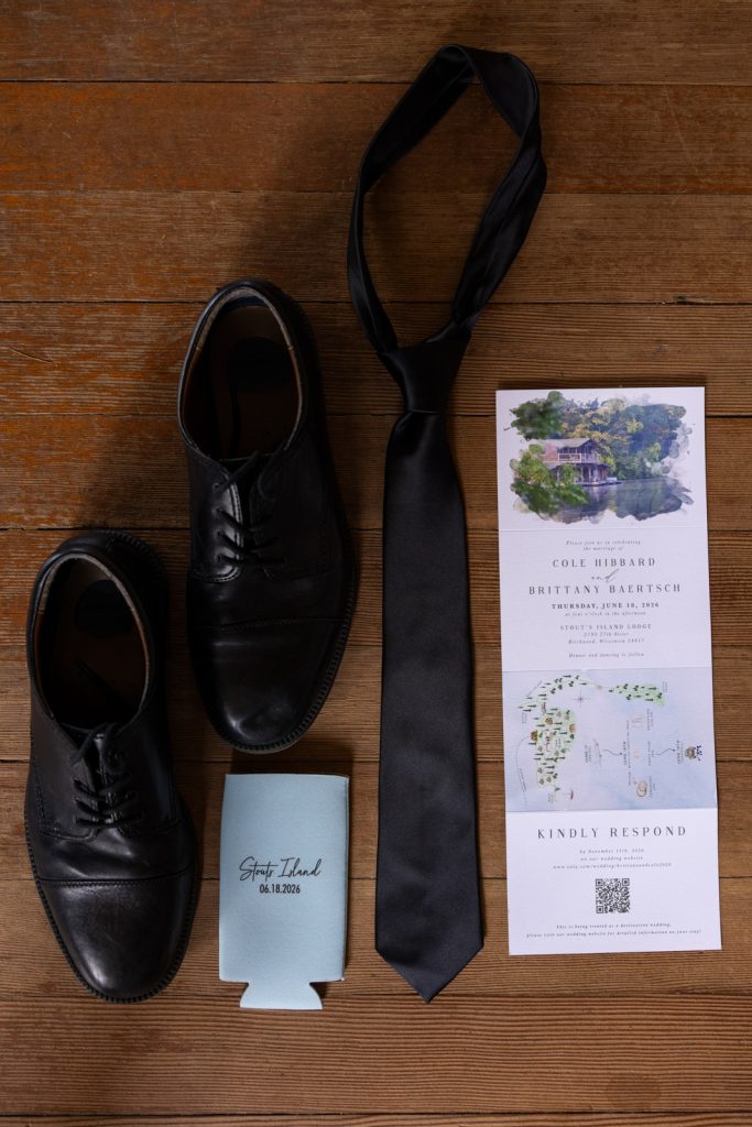 Brittany and Cole's Stout’s Island wedding details: shoes, tie, and invitation.