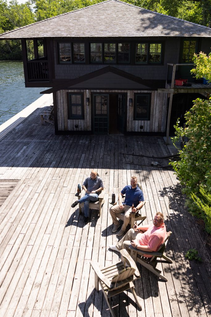 Stout’s Island Lodge boathouse on Red Cedar Lake and wedding guests relaxing on the deck.