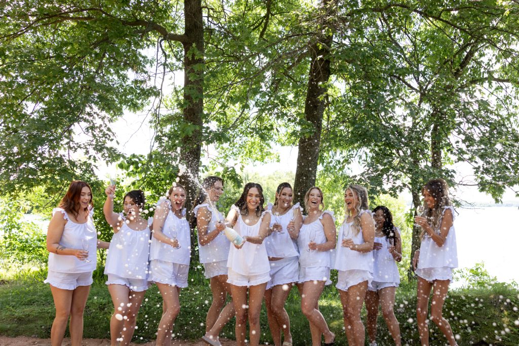 Brittany's wedding party celebrating with champagne on Stout’s Island, Birchwood, Wisconsin.