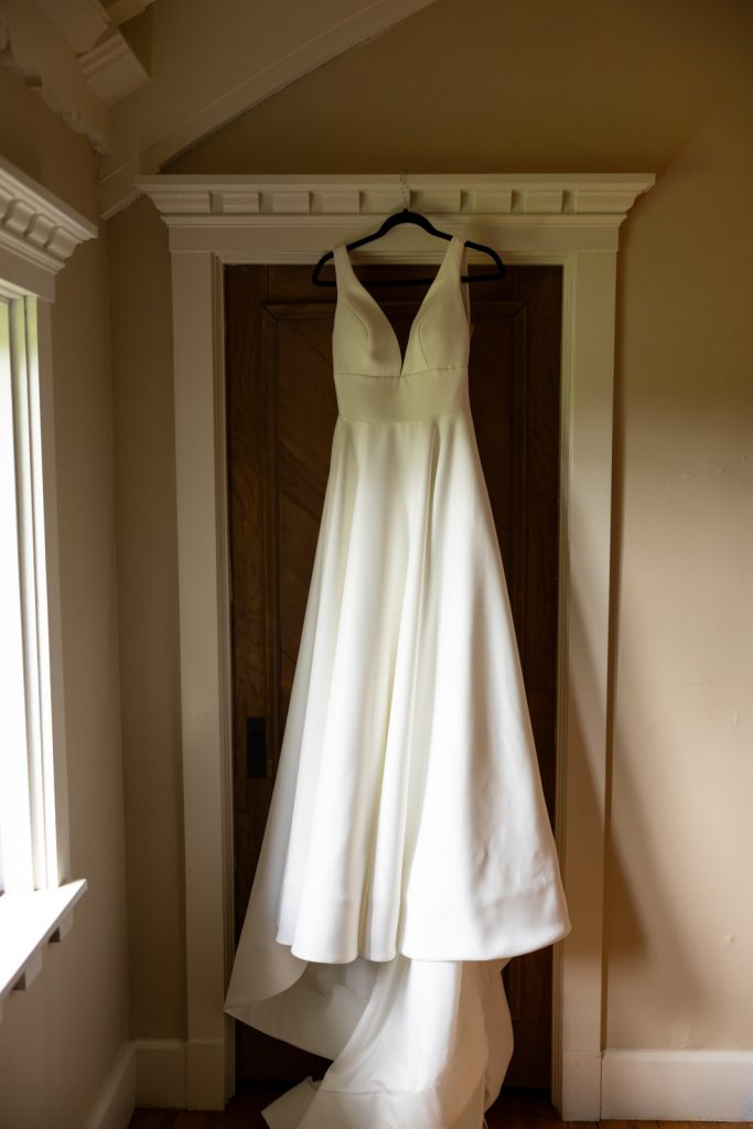 Brittany's wedding dress hanging on door at Stout’s Island wedding venue in Birchwood, Wisconsin.