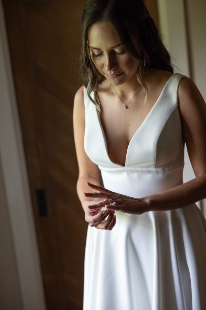 Brittany getting ready in wedding dress at Stout’s Island Lodge, Wisconsin wedding.