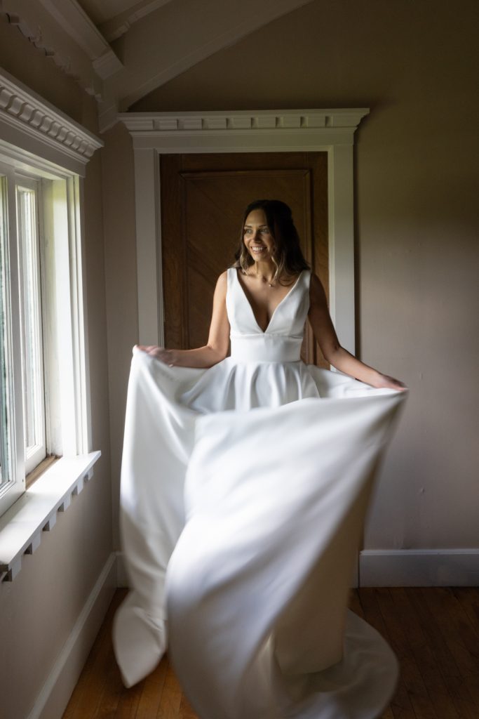 Bride in white wedding dress near window at Stout’s Island Lodge, Birchwood, Wisconsin.