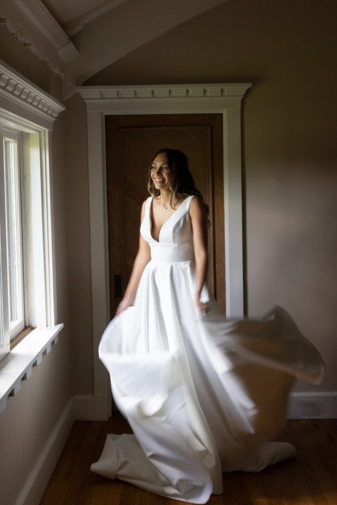 Bride in wedding dress near window at Stout’s Island Lodge, Birchwood, Wisconsin.