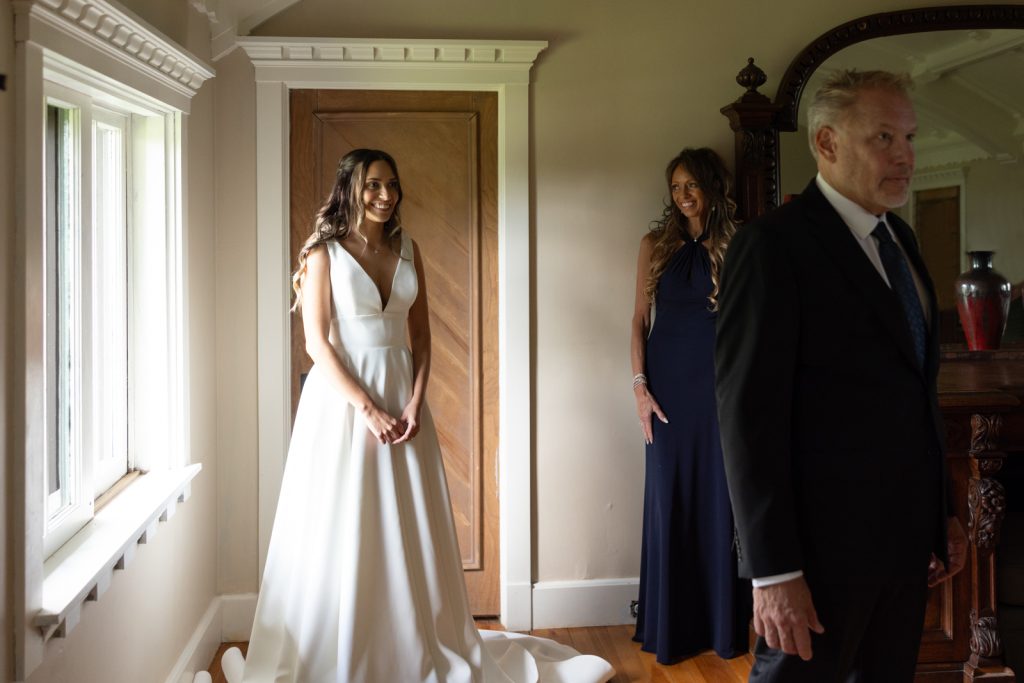 Brittany in wedding dress and mother looking on at Stout’s Island wedding in Wisconsin