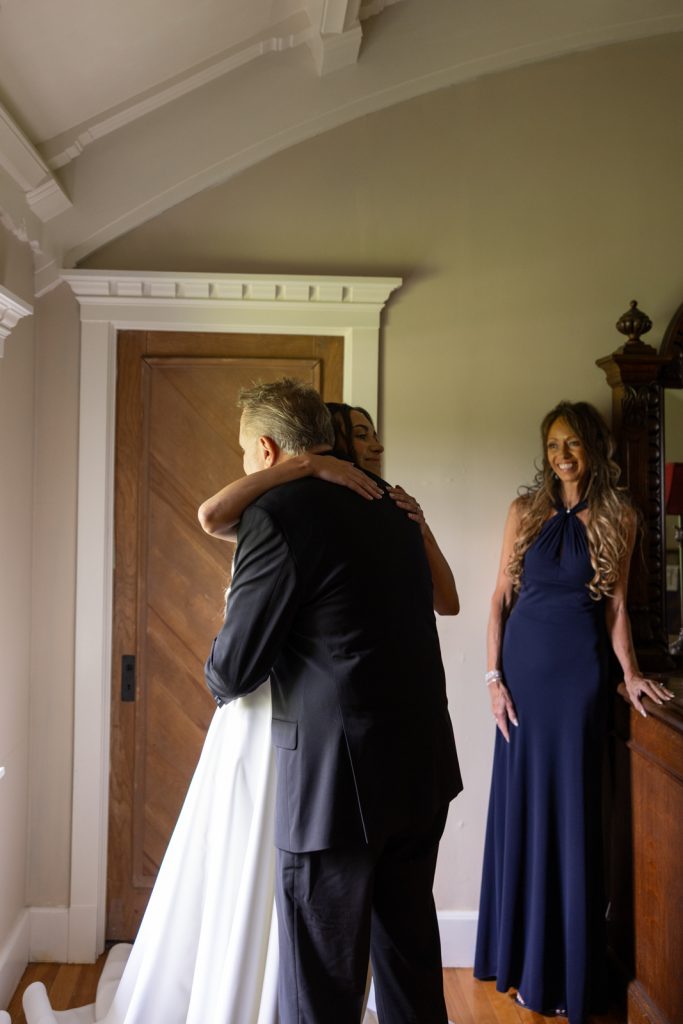 Bride in wedding dress embracing father at Stout’s Island wedding in Wisconsin.