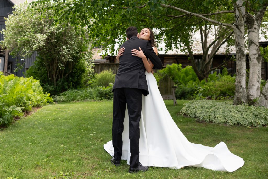 Brittany and Cole embracing on Stout’s Island wedding day, Birchwood Wisconsin.