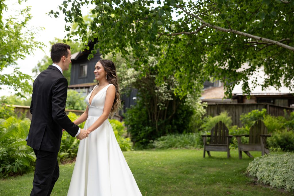 Brittany and Cole holding hands on Stout’s Island, Wisconsin wedding day.