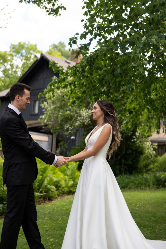 Brittany and Cole holding hands at their Stout’s Island wedding in Birchwood, Wisconsin.