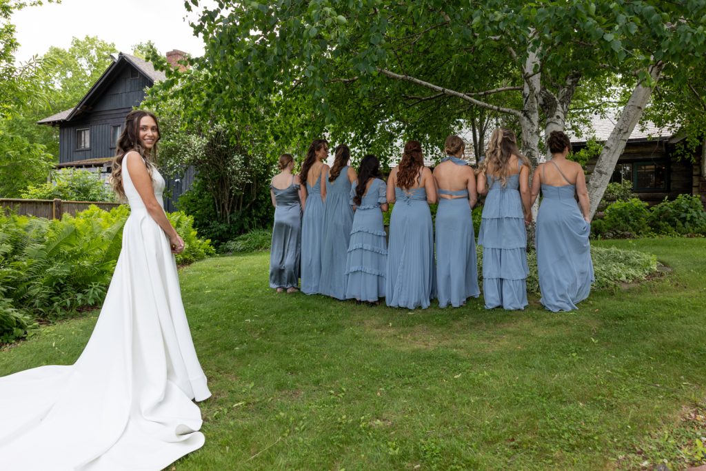 Bride in wedding dress and bridesmaids in blue dresses at Stout’s Island wedding in Birchwood,