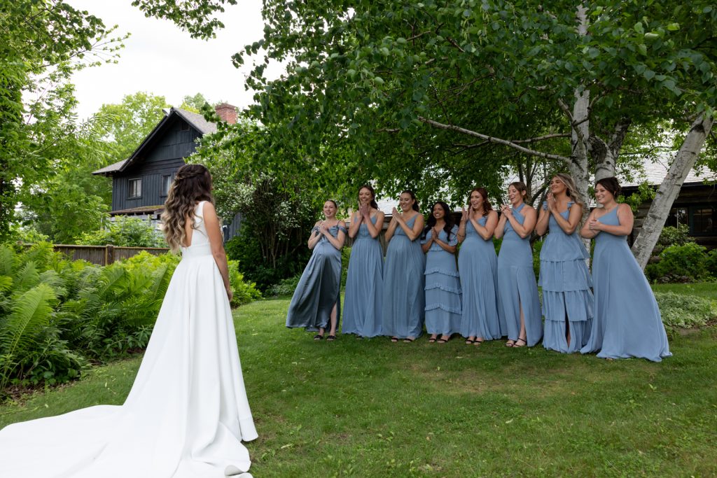 Bride in wedding dress facing bridesmaids in blue dresses at Stout’s Island wedding in Wisconsin.