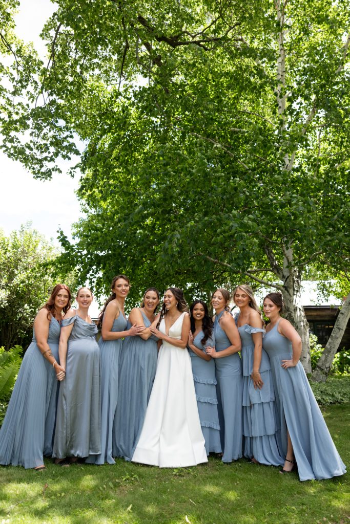 Brittany the bride with bridesmaids in blue dresses at Stout’s Island wedding in Wisconsin.