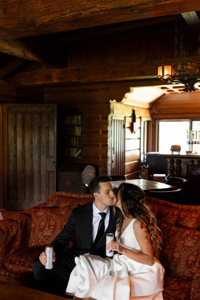 Brittany and Cole kissing on a vintage couch at Stout’s Island Lodge wedding in Wisconsin.
