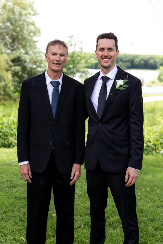 Brittany and Cole with fathers at Stout’s Island wedding in Birchwood, Wisconsin.