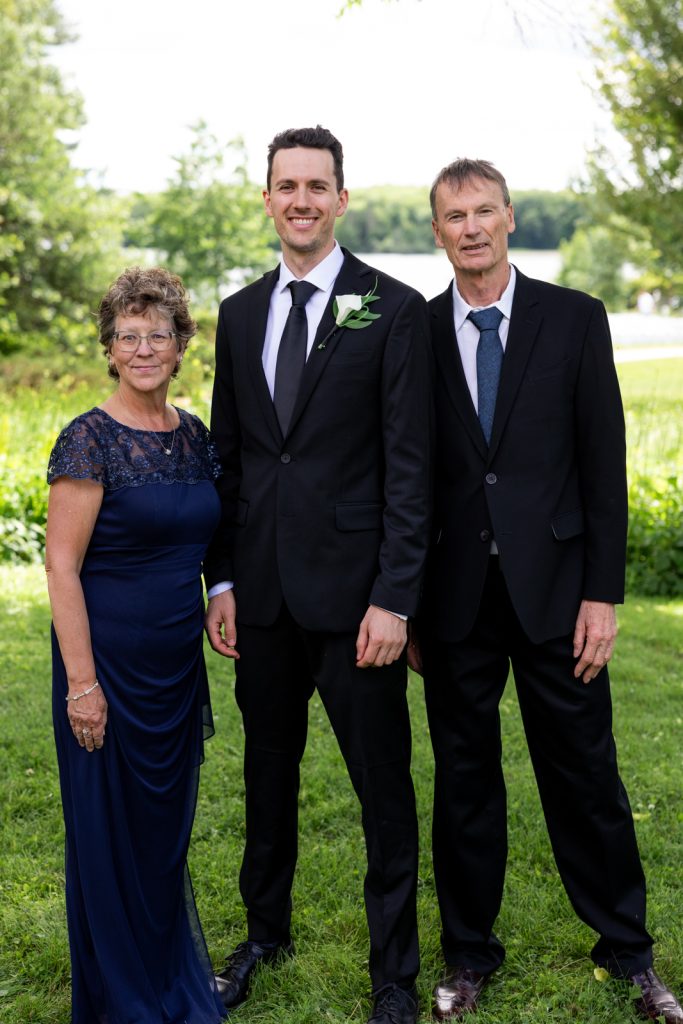 Brittany and Cole's Stout's Island wedding: Groom and family portrait on Red Cedar Lake.
