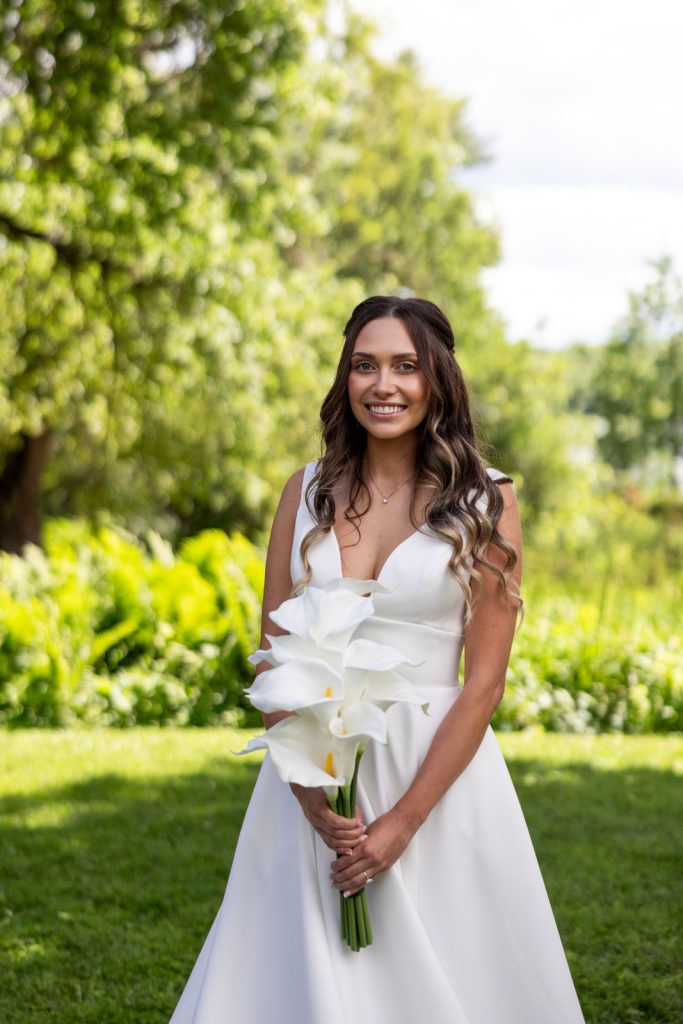Bride holding white lilies at Stout’s Island wedding in Wisconsin.