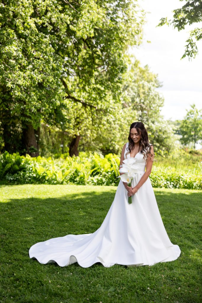 Bride in white wedding gown holding bouquet on Stout’s Island, Wisconsin wedding.