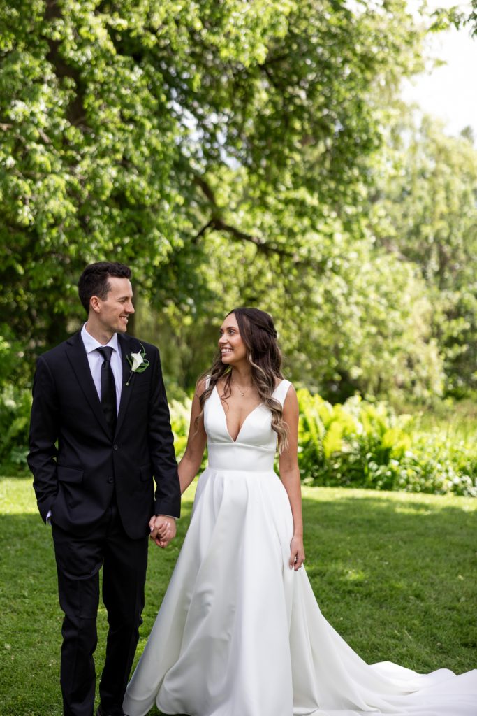 Brittany and Cole, the happy couple, holding hands on Stout’s Island wedding day in Wisconsin.