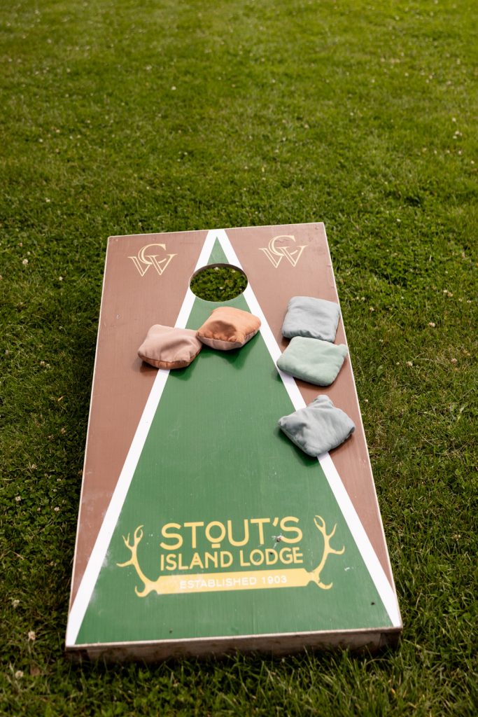 Cornhole game with Stout’s Island Lodge logo at Brittany and Cole’s Wisconsin wedding.