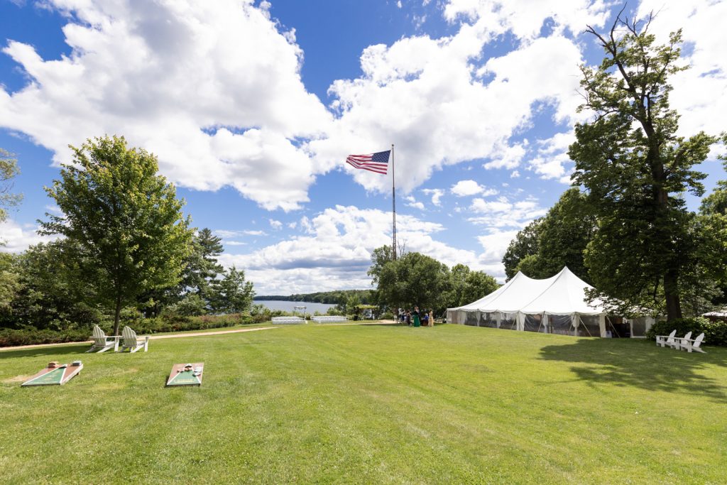 Stout’s Island wedding reception tent and lawn with American flag and lake view.