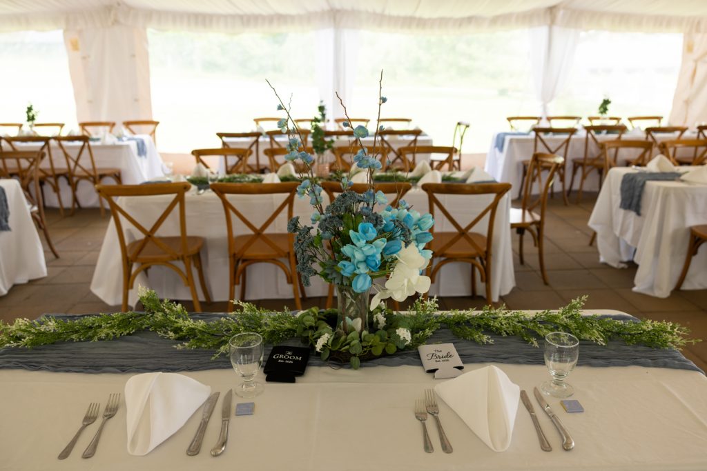 Wedding reception tablescapes with blue floral arrangements and linens at Stout’s Island, Wisconsin.