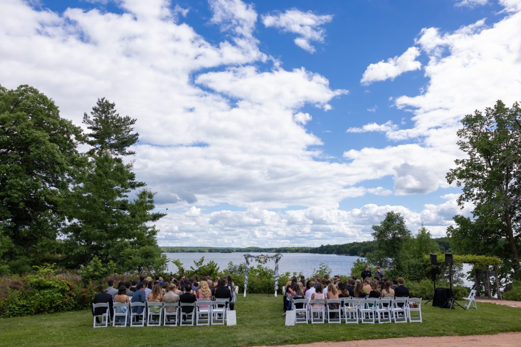 Stout’s Island wedding ceremony on Red Cedar Lake with a floral arch and blue sky