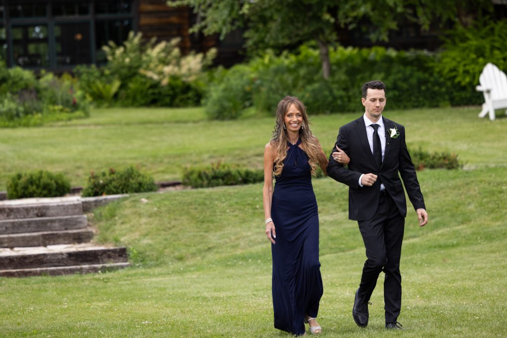 Brittany and Cole walking on Stout’s Island lawn during their Wisconsin wedding.
