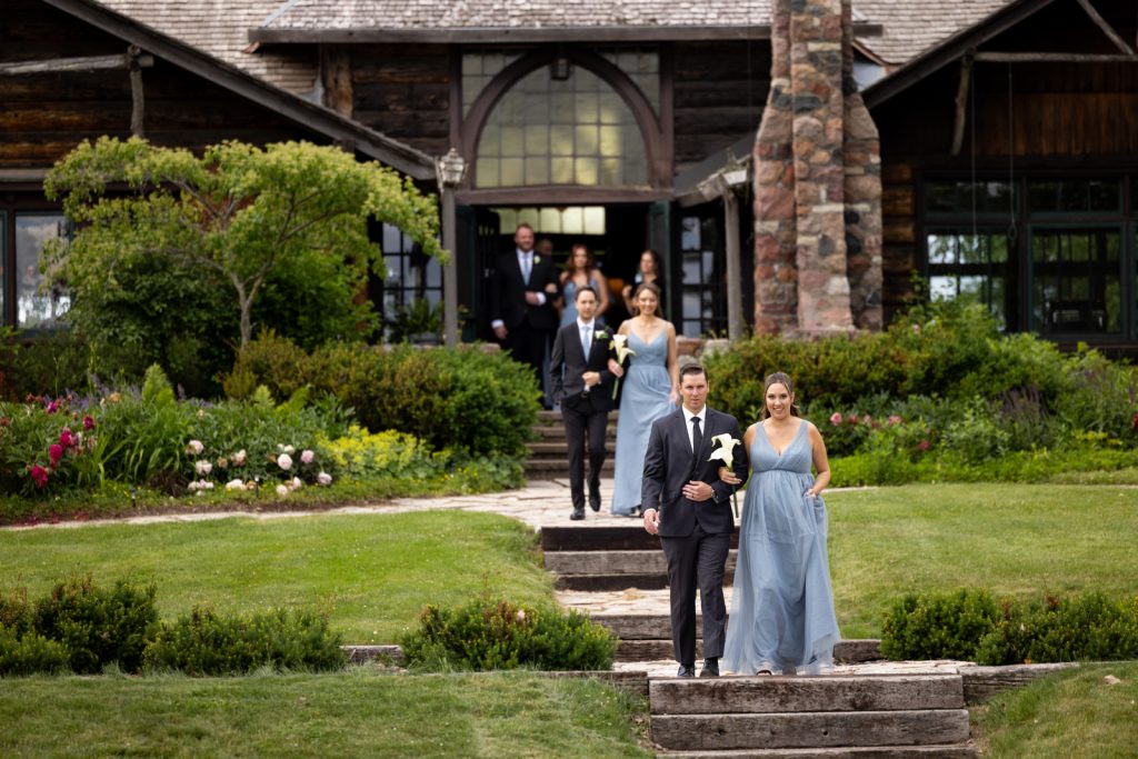 Brittany and Cole walking down stairs at Stout’s Island wedding ceremony, Birchwood Wisconsin.