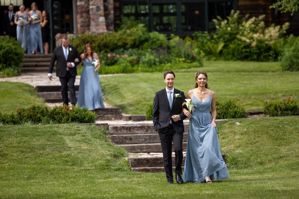 Brittany and Cole walking on steps at Stout’s Island wedding in Birchwood, Wisconsin, with wedding