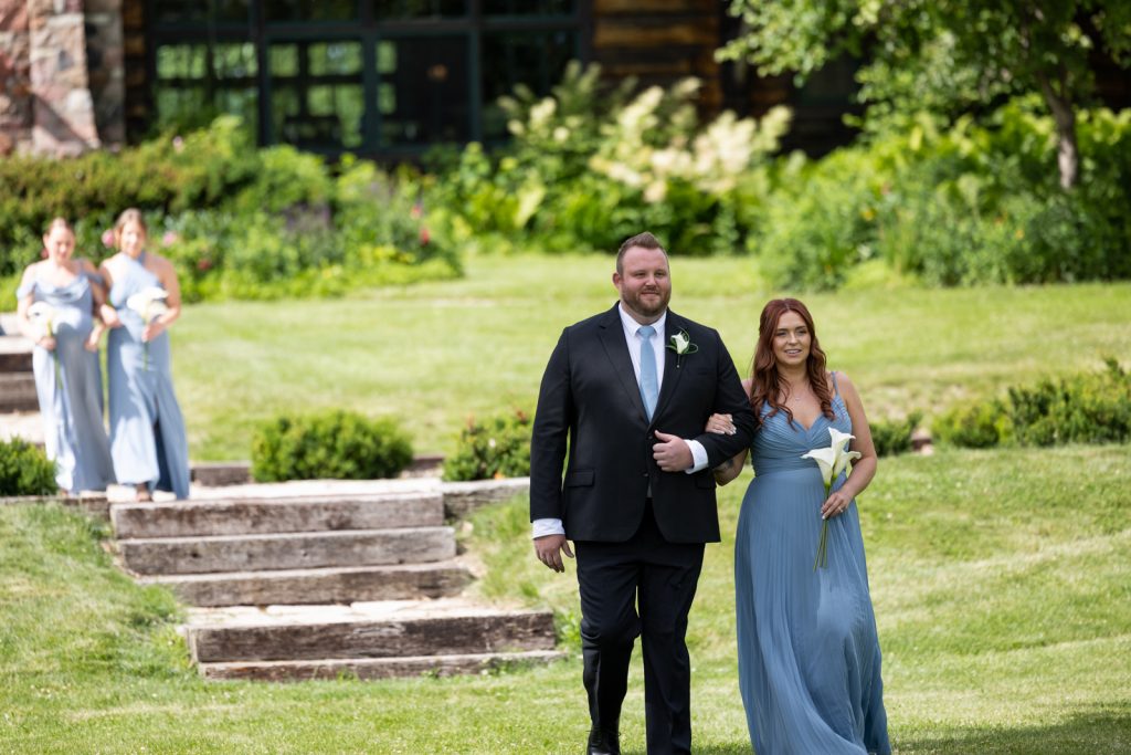 Brittany and Cole walking down stairs at Stout’s Island wedding ceremony, Wisconsin.