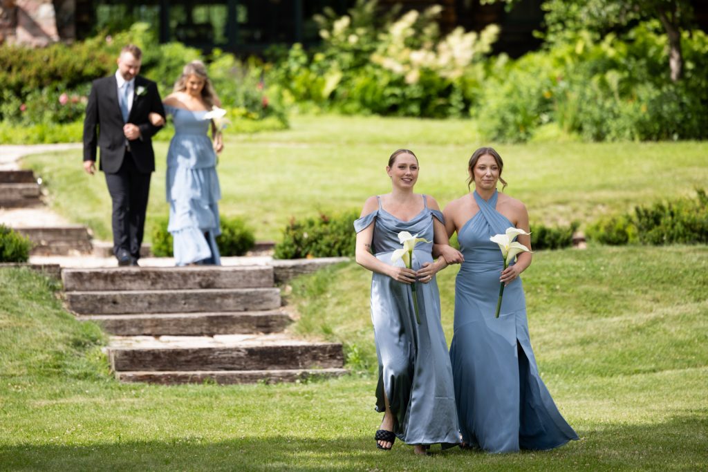 Bride and bridesmaids walking on steps at Stout’s Island wedding in Birchwood, Wisconsin.