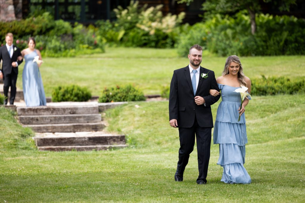 Brittany and Cole wedding party walking on Stout’s Island lawn, Birchwood, Wisconsin.