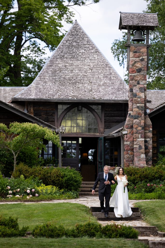 Brittany and Cole walking down steps at Stout’s Island Lodge, Wisconsin wedding venue.