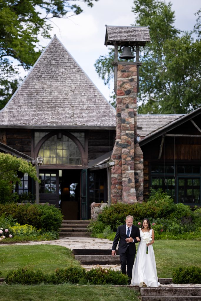 Brittany and Cole walking toward the bell tower at Stout’s Island wedding in Birchwood, Wisconsin.