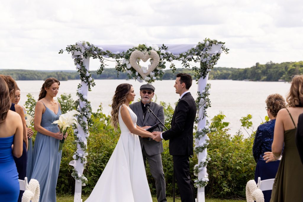 Brittany and Cole's wedding ceremony at Stout’s Island on Red Cedar Lake, Wisconsin, with floral