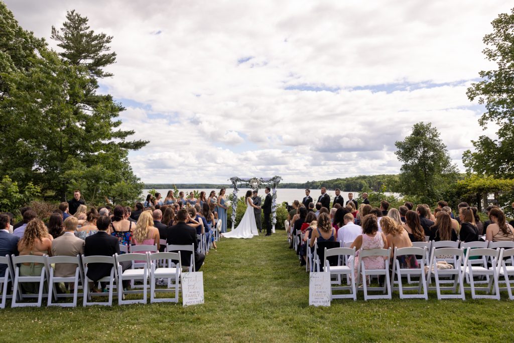 Brittany and Cole's wedding ceremony on Stout’s Island with lakeside views and floral arch.
