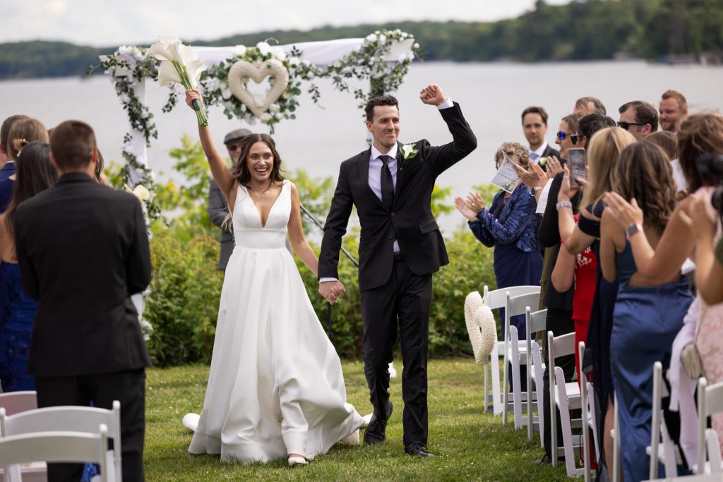 Brittany and Cole wedding ceremony on Stout’s Island, Wisconsin, with lakeside view and floral arch.
