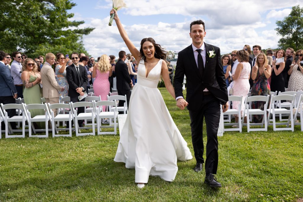 Brittany and Cole, the happy couple, walking hand-in-hand at their Stout’s Island wedding ceremony.