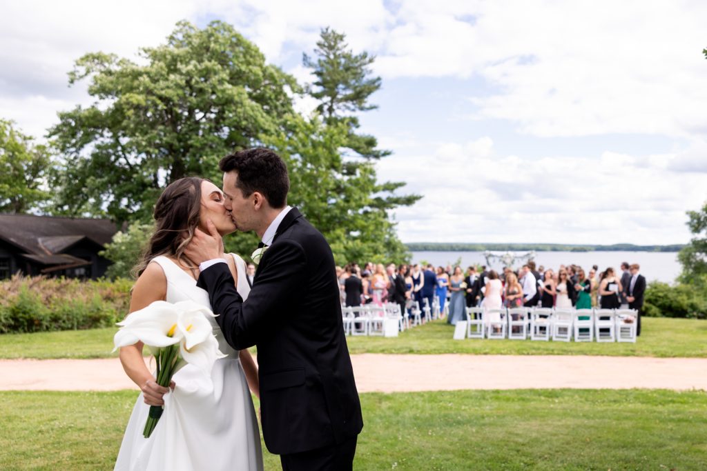 Brittany and Cole kissing during their Stout’s Island wedding ceremony and reception on Red Cedar