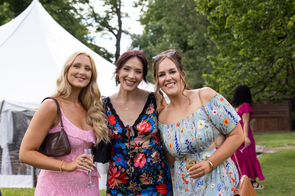 Brittany and wedding guests smiling together at Stout’s Island wedding in Birchwood, Wisconsin.