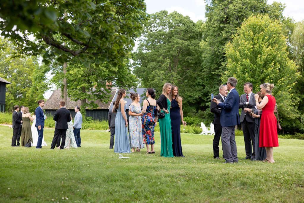 Wedding guests mingling on Stout’s Island lawn, Birchwood, Wisconsin.