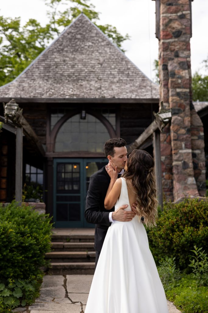 Brittany and Cole sharing a kiss at Stout’s Island Lodge wedding in Wisconsin.