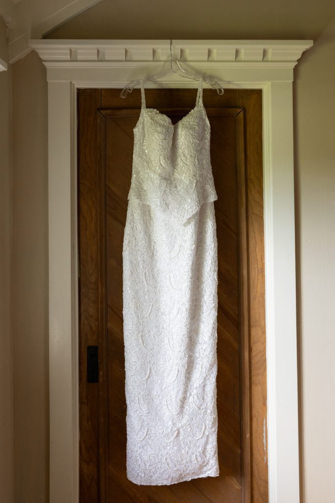 Wedding dress hanging on door at Stout’s Island wedding in Birchwood, Wisconsin