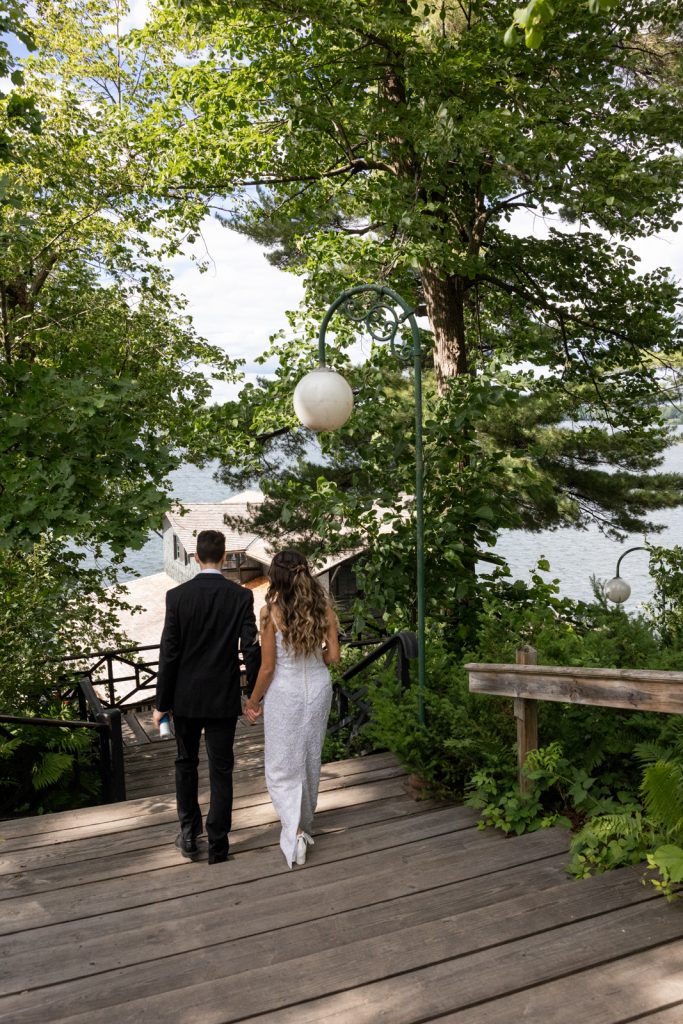 Brittany and Cole walking on stairs at Stout’s Island wedding, Red Cedar Lake in the